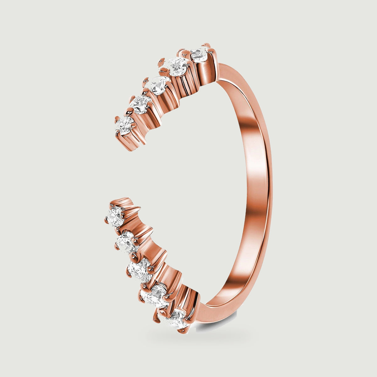 A rose gold vermeil band stands at an angle, revealing its rounded shank and individual stone settings.