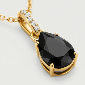 An angled close-up shows a black pear-shaped stone held by yellow gold vermeil prongs beside a sparkling bail.