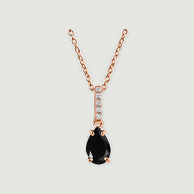A rose gold vermeil necklace displays a glossy black teardrop stone and a narrow clear-stone bail on pale gray.