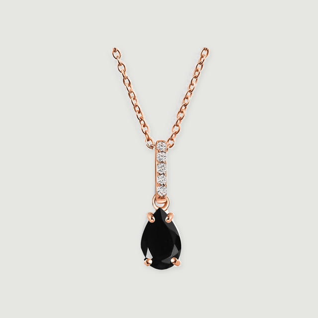 A rose gold vermeil necklace displays a glossy black teardrop stone and a narrow clear-stone bail on pale gray.