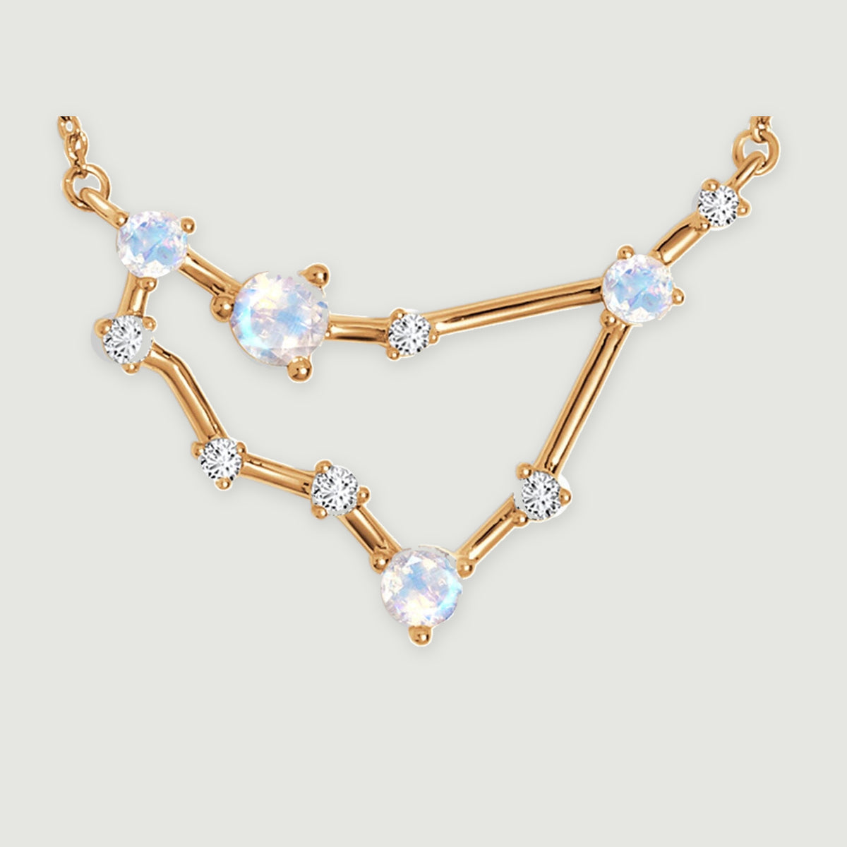 A close view shows the yellow gold bars joining round iridescent stones and small clear accents.