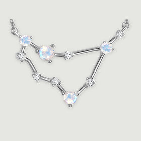 The silver necklace centerpiece displays reflective round stones, fine prongs, and slender connecting bars.