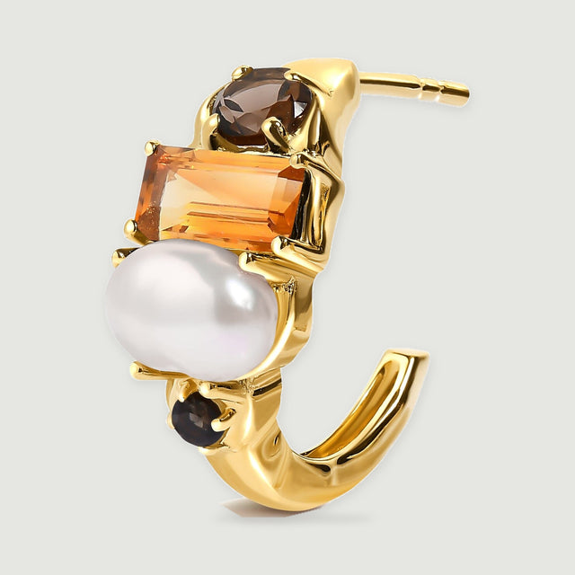 One gold-tone earring is shown at an angle with its curved open hoop and straight post visible behind the pearl and stones.