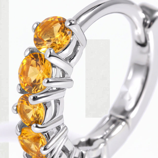 Round yellow citrine stones sit between bright silver-tone prongs in a detailed close-up.