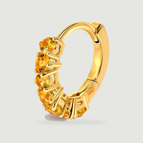An upright gold-tone citrine hoop reveals its curved band and the side of its gemstone settings.