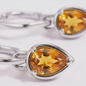 Faceted amber citrine and the polished white rhodium plated setting fill this close-up.