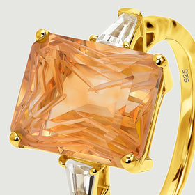 An angled close view reveals the carved citrine facets, gold corner prongs, and clear tapered side stones.