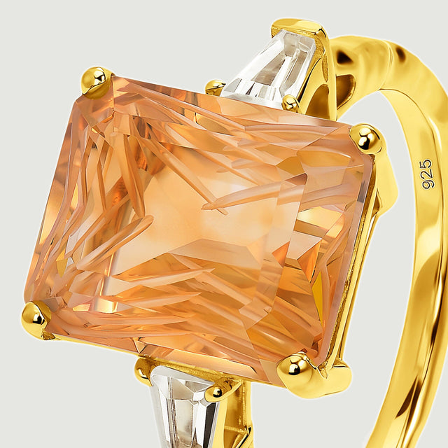 An angled close view reveals the carved citrine facets, gold corner prongs, and clear tapered side stones.