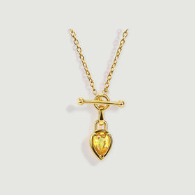 A yellow gold plated chain carries a yellow pear shaped gemstone below a polished horizontal bar.