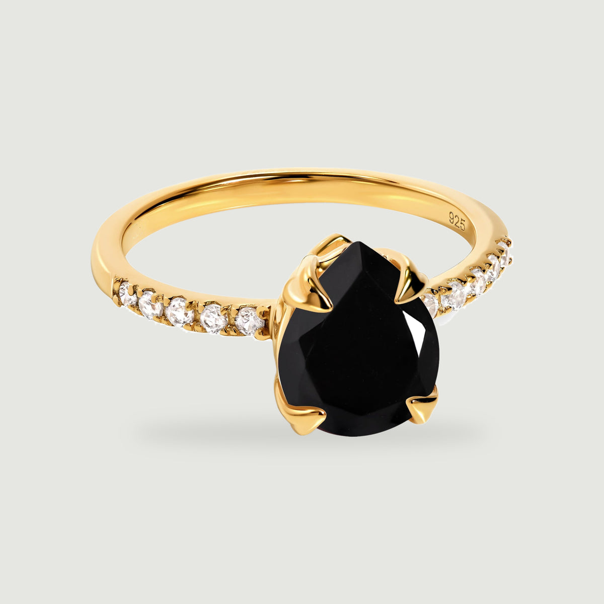 A yellow gold vermeil ring displays a black pear-shaped stone above a band lined with small clear stones.