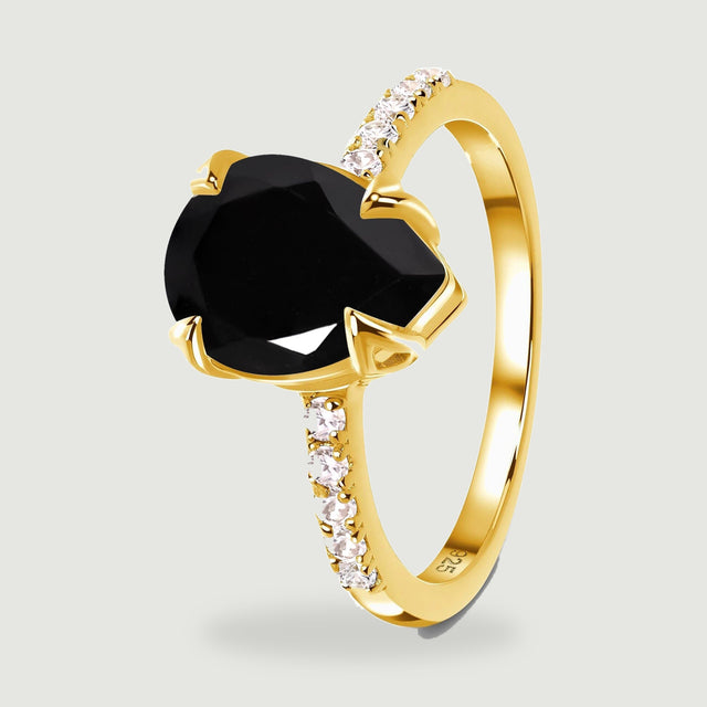 The side of a yellow gold vermeil ring reveals a slender band and a pear-shaped black stone held above it.