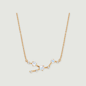 A yellow gold necklace has three pale iridescent round stones and five smaller clear stones linked by polished bars.
