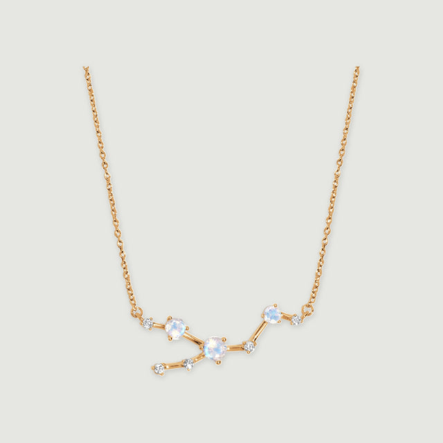 A yellow gold necklace has three pale iridescent round stones and five smaller clear stones linked by polished bars.