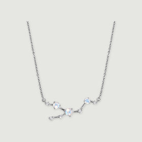 A silver necklace displays an asymmetric arrangement of round iridescent stones and small clear accents.