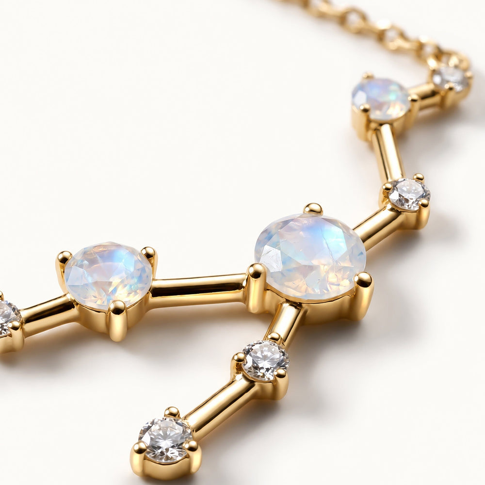 Faceted pale stones and small clear stones sit in polished yellow gold prong settings.