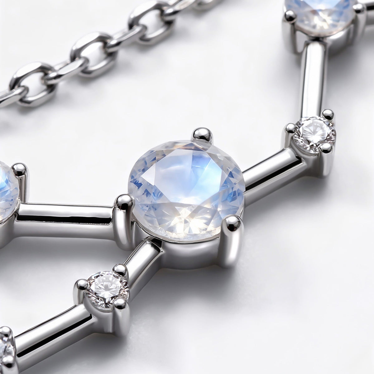 A close view shows a blue flashing round stone beside clear accents and reflective silver bars.