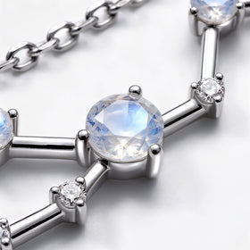 A close view shows a blue flashing round stone beside clear accents and reflective silver bars.