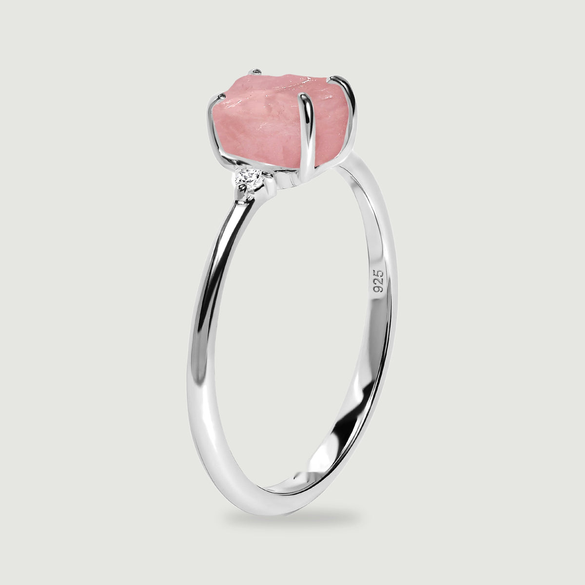 The upright silver ring shows its raised pink stone, curved prongs, and narrow band from the side.