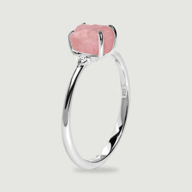 The upright silver ring shows its raised pink stone, curved prongs, and narrow band from the side.