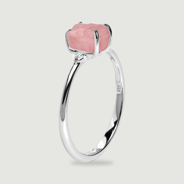 The upright silver ring shows its raised pink stone, curved prongs, and narrow band from the side.