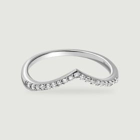 A white gold chevron ring with round diamonds is centered on a pale gray surface.