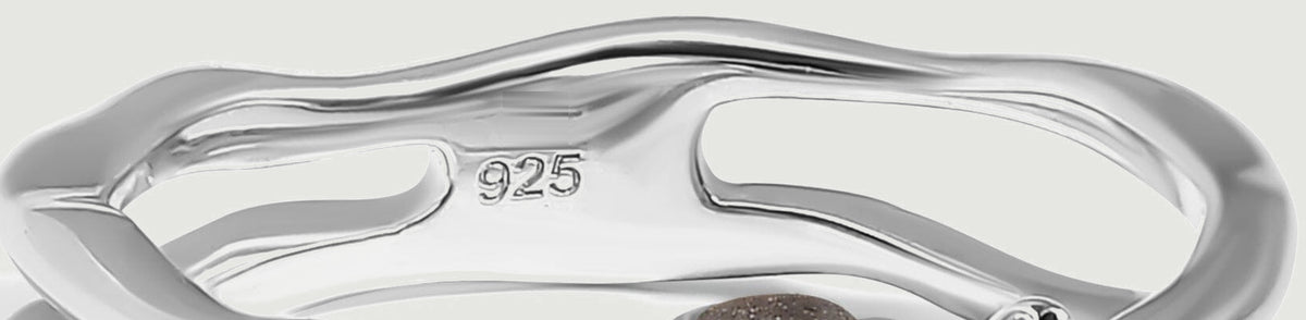 The back of the silver ring shows curved openwork, a polished inner band, and a 925 purity stamp.
