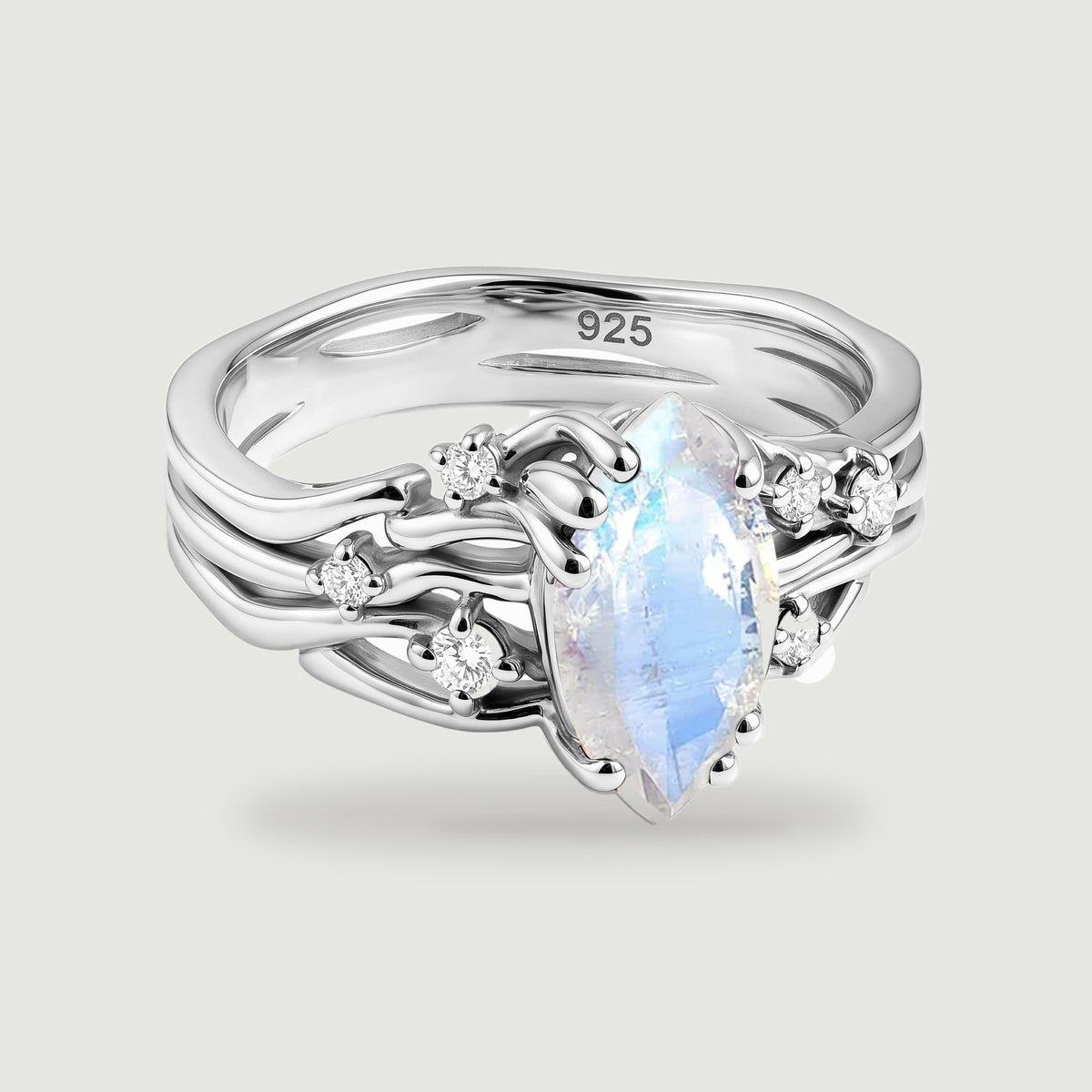 A sterling silver ring shows a blue flashing marquise moonstone framed by polished curves and clear round stones.