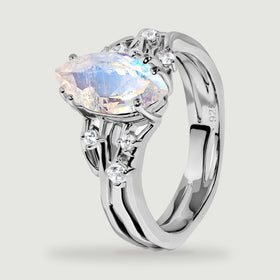 The side of a sterling silver ring reveals the faceted moonstone, clear accent stones, and a polished inner band.