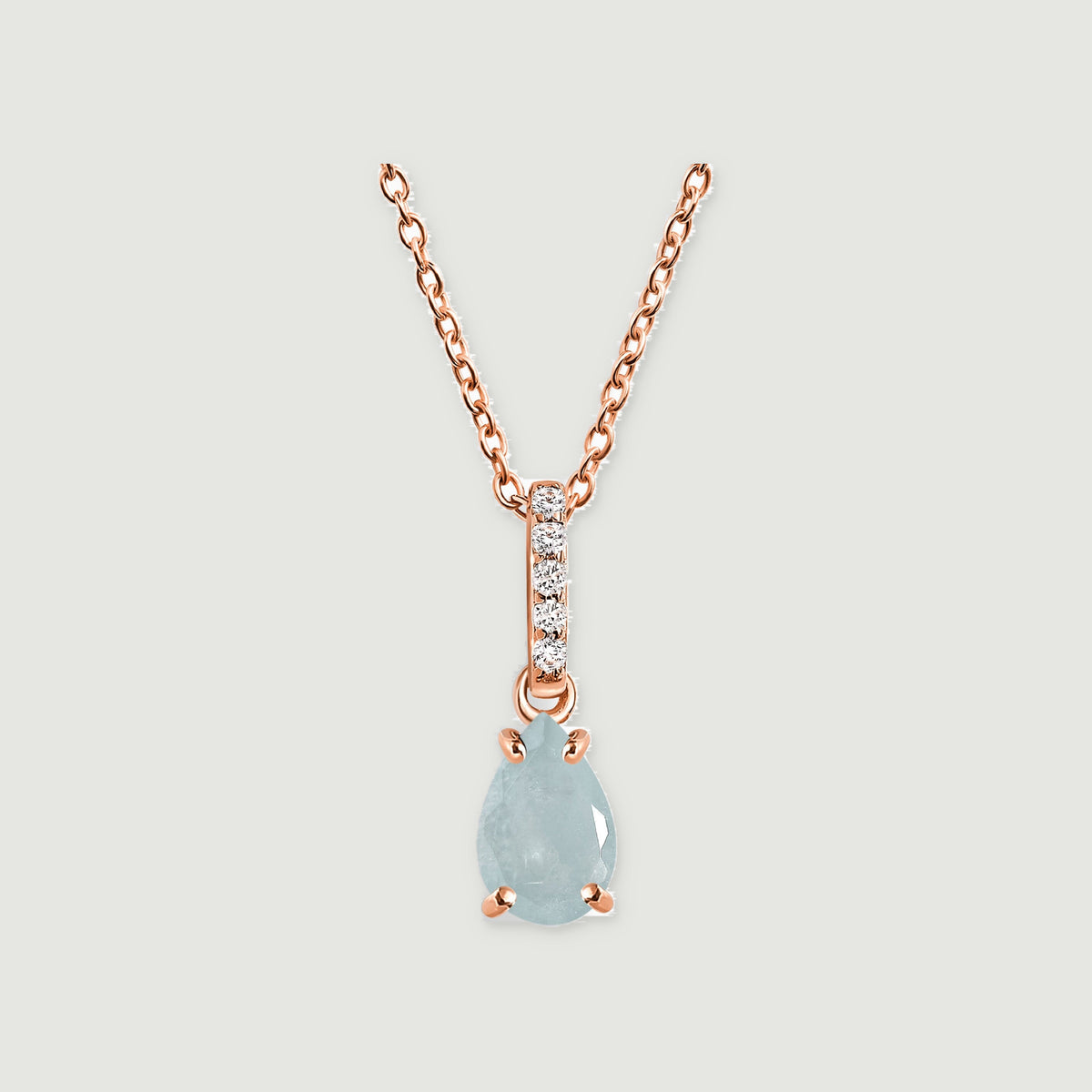 A rose gold chain holds a teardrop aquamarine below a slim bail set with five clear stones.