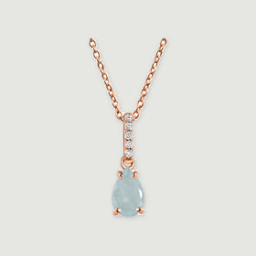 A rose gold chain holds a teardrop aquamarine below a slim bail set with five clear stones.