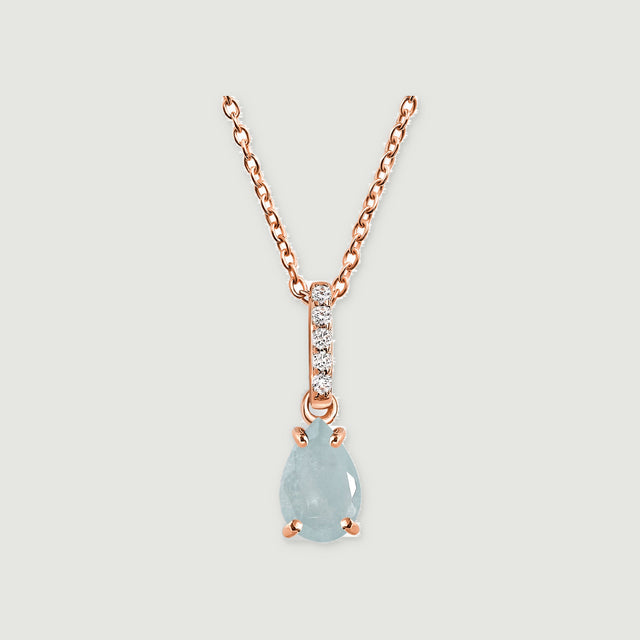 A rose gold chain holds a teardrop aquamarine below a slim bail set with five clear stones.