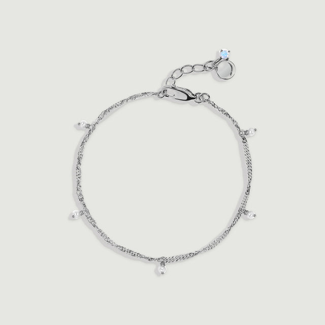A silver anklet forms an oval with five dangling pearls and a lobster clasp on light gray.