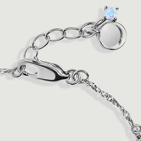 A close view shows the silver clasp, extension links and round end charm against light gray.