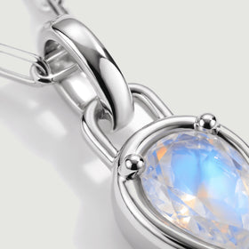 A close-up shows the polished silver-tone bail, rounded prongs, and blue reflections inside the moonstone.