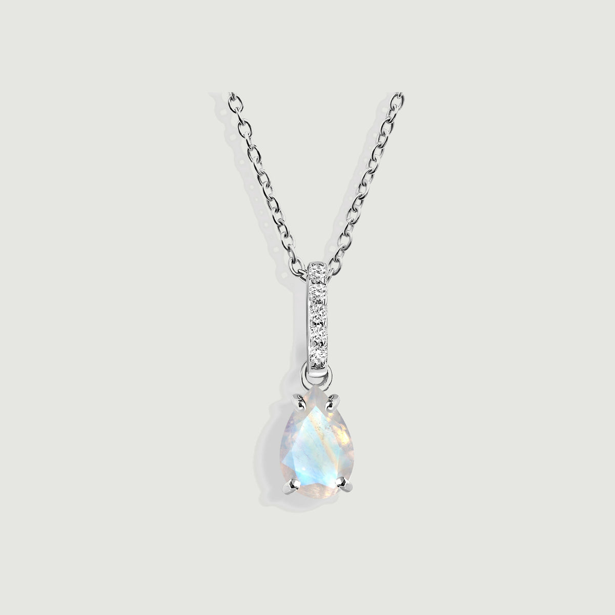 A pear-shaped moonstone hangs below a five-diamond bail on a sterling silver chain against a light gray background.