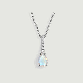 A pear-shaped moonstone hangs below a five-diamond bail on a sterling silver chain against a light gray background.