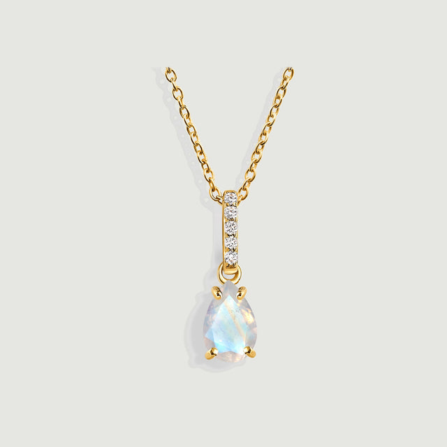 A yellow gold vermeil necklace displays a faceted pear-shaped moonstone and a vertical row of five diamonds on light gray.