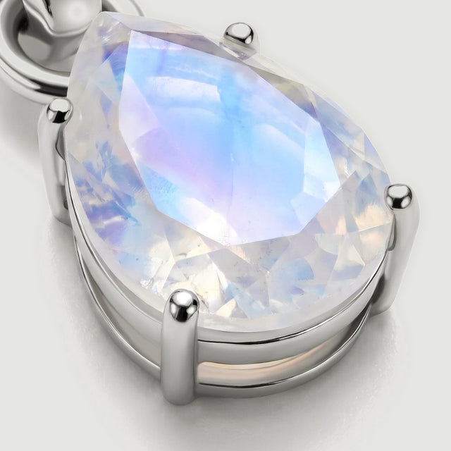 An angled close-up shows the raised silver prongs and the open setting beneath the faceted moonstone.