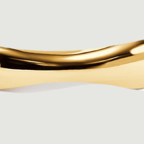 A close view shows the broad polished waves along the front of the yellow gold band.