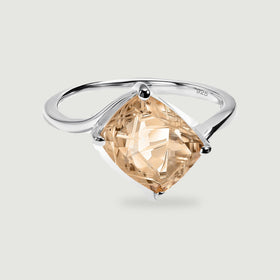 A sterling silver band frames a champagne quartz gemstone in a four-prong setting against light gray.