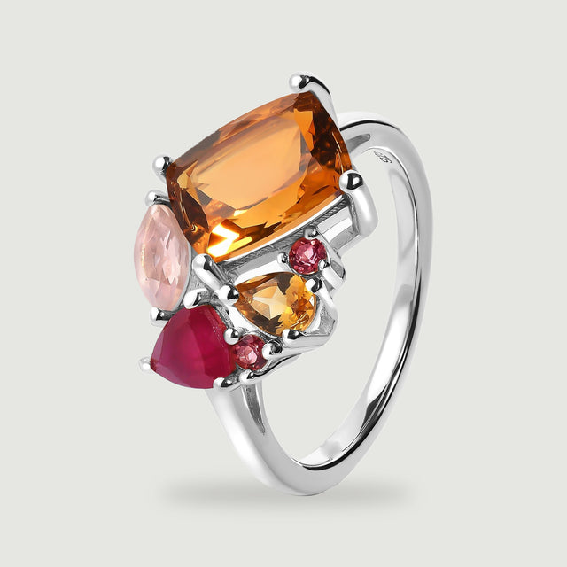 An angled silver ring reveals the open space beneath its gemstone cluster and the curve of its polished band.