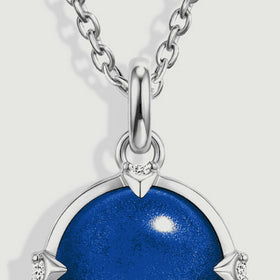 Oval silver chain links meet a polished bail above the top of the round blue pendant.