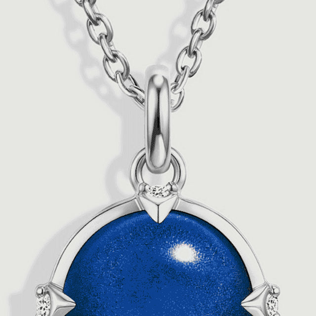 Oval silver chain links meet a polished bail above the top of the round blue pendant.