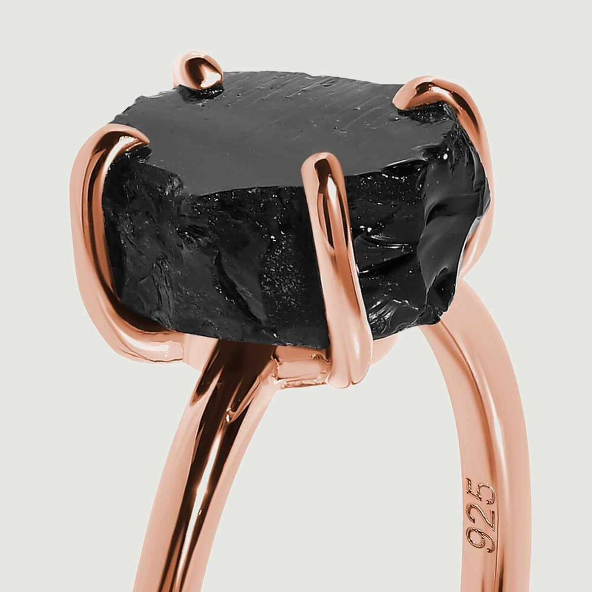 A close view reveals the glossy fractures of black obsidian held in a rose gold vermeil setting.