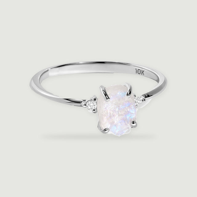 A white gold ring shows a translucent moonstone with blue reflections and four curved prongs.
