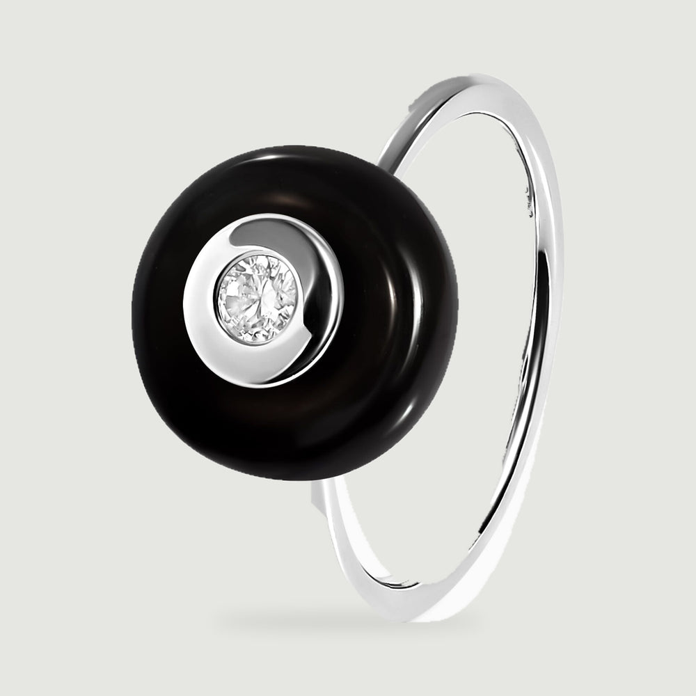 An upright silver ring shows the raised black stone and the slender band from an angled side view.