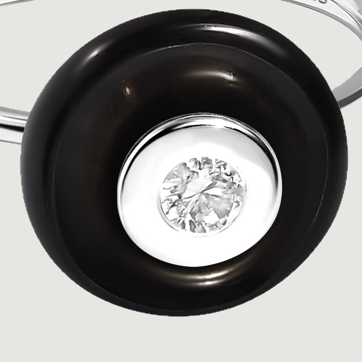 A close view reveals the silver bezel and clear faceted center surrounded by smooth black obsidian.
