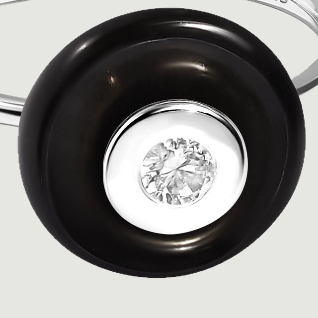 A close view reveals the silver bezel and clear faceted center surrounded by smooth black obsidian.