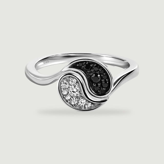 A silver ring displays black and clear stone clusters within a flowing circular setting.
