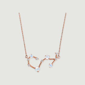 A rose gold necklace with linked round moonstones and small diamonds is centered on a light gray background.